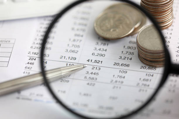 View at financial details in table thru magnifying glass close-up View at financial details in table thru magnifying glass close-up